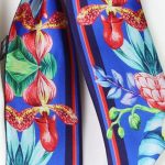 Szalik jedwabny twilly włoski w kolorze niebieskim z eleganckim wzorem kwiatowym,